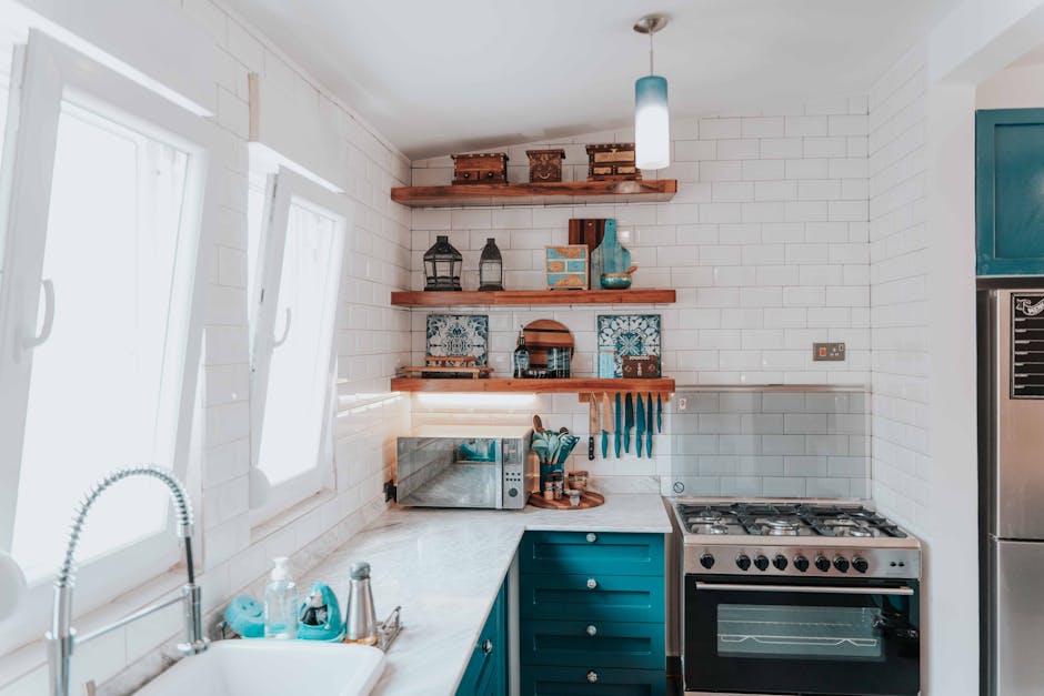 Bright and stylish modern kitchen featuring blue accents, wooden shelves, and stainless steel appliances.