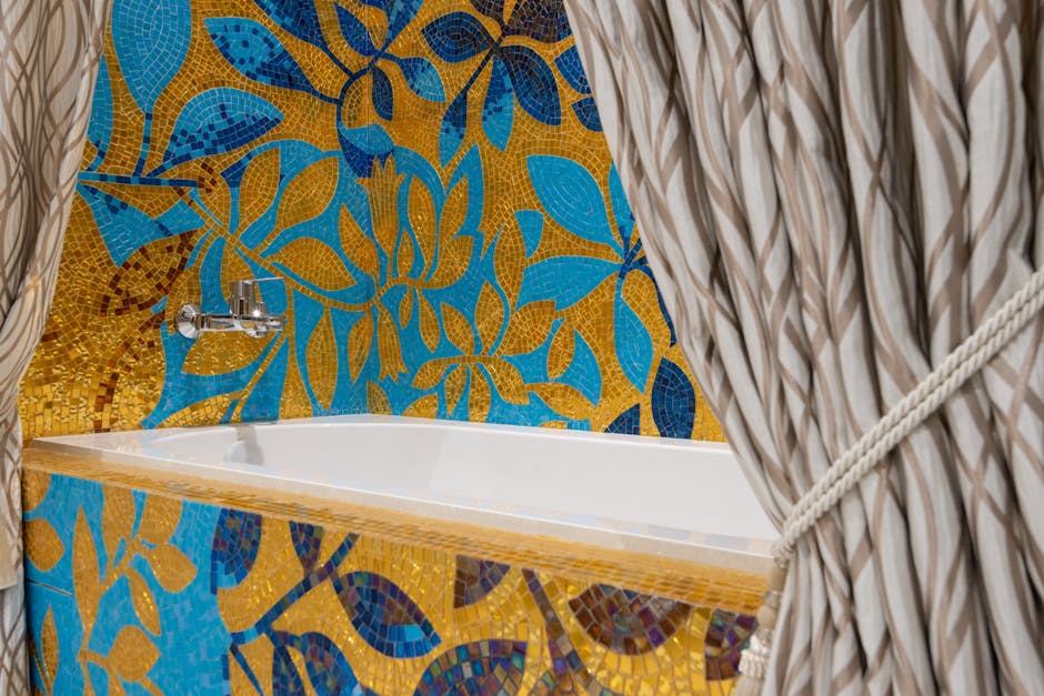 Vibrant bathtub design with floral mosaic tiles and stylish curtains.